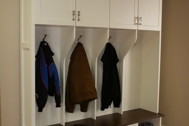 Mid-sized elegant medium tone wood floor and brown floor mudroom photo in New York with beige walls