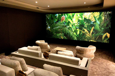 Design ideas for a large contemporary enclosed home cinema in New York with brown walls, carpet, a projector screen and beige floors.