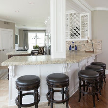 White kitchen w/ travertine floor transition to hardwood