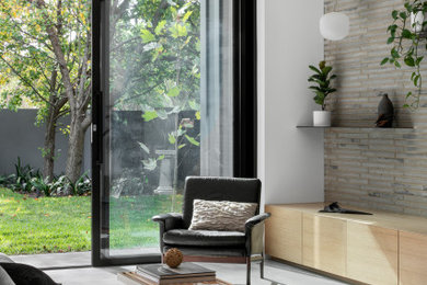 Inspiration for a large modern living room in Melbourne with grey floor, brick walls, grey walls and porcelain floors.