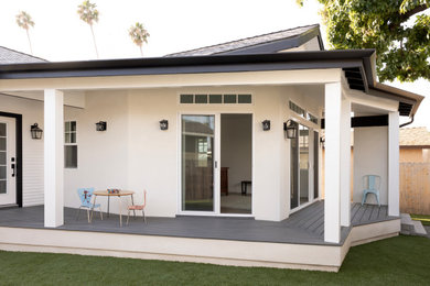Modelo de terraza de estilo americano de tamaño medio en patio trasero y anexo de casas con cocina exterior y entablado
