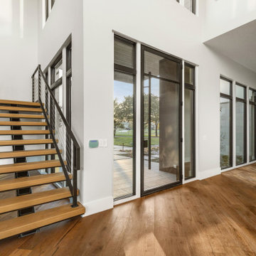 Modern Floating Staircase with Contemporary Metal Railing and Warm Wood Finishes