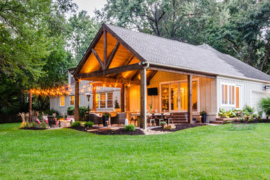 Mid-sized mountain style backyard stamped concrete patio kitchen photo in Kansas City with a roof extension