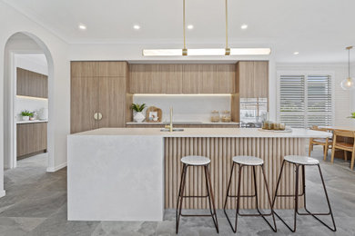 Mid-sized contemporary galley eat-in kitchen in Sunshine Coast with an undermount sink, quartz benchtops, grey splashback, stone tile splashback, stainless steel appliances, grey benchtop, flat-panel cabinets, light wood cabinets and grey floor.