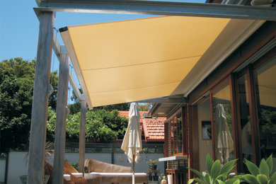 This is an example of a contemporary backyard patio in Sydney with an awning.