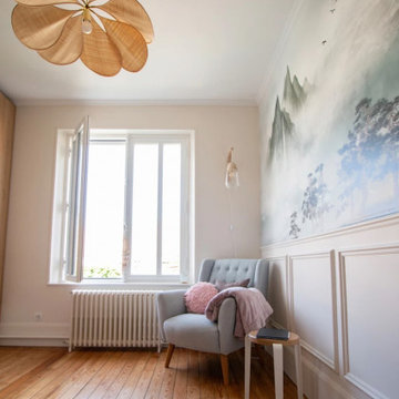 Fauteuil gris et papier peint panoramique avec une suspension pétal en raphia