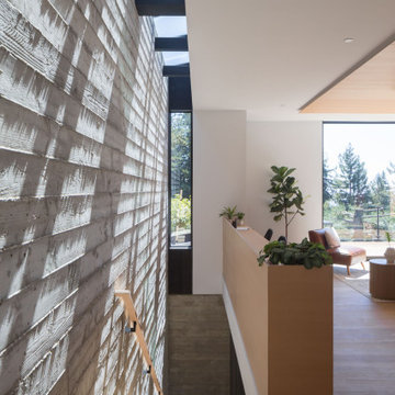 Interior board-formed concrete retaining wall with continuous skylight slot