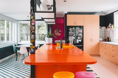 Contemporary kitchen in Other with an undermount sink, laminate benchtops, white splashback, ceramic splashback, black appliances, painted wood floors, with island, pink floor and orange benchtop.