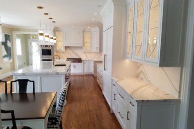 Expansive traditional l-shaped eat-in kitchen in Baltimore with an undermount sink, beaded inset cabinets, white cabinets, quartz benchtops, white splashback, engineered quartz splashback, panelled appliances, medium hardwood floors, with island, brown floor and white benchtop.