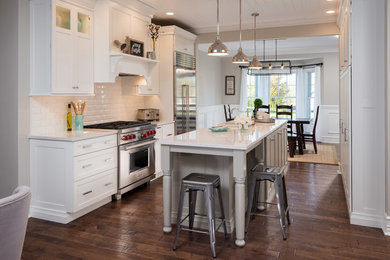 Eat-in kitchen - mid-sized transitional galley medium tone wood floor and brown floor eat-in kitchen idea in Boston with a farmhouse sink, shaker cabinets, white cabinets, quartz countertops, white backsplash, ceramic backsplash, stainless steel appliances and no island