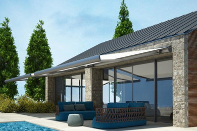 Patio - contemporary backyard patio idea in Other with an awning