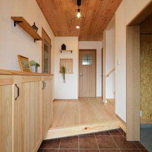 他の地域のカントリー風おしゃれな玄関 (白い壁、茶色い床) の写真