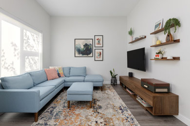 Inspiration for a mid-century modern medium tone wood floor and brown floor family room remodel in Vancouver with a wall-mounted tv