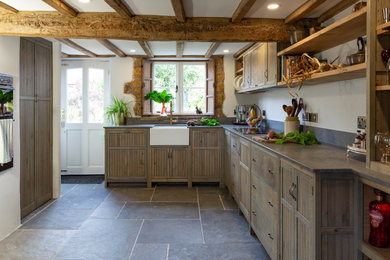 Design ideas for a medium sized rustic grey and white galley kitchen/diner in West Midlands with a belfast sink, shaker cabinets, green cabinets, quartz worktops, grey splashback, engineered quartz splashback, integrated appliances, slate flooring, no island, grey floors, grey worktops, exposed beams and a chimney breast.