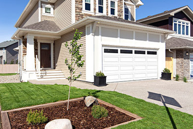 Inspiration for a mid-sized transitional beige two-story vinyl exterior home remodel in Calgary