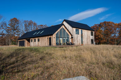Danish two-story wood and clapboard exterior home photo in New York with a metal roof and a black roof