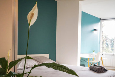 Großes Modernes Schlafzimmer mit blauer Wandfarbe und hellem Holzboden in Sonstige
