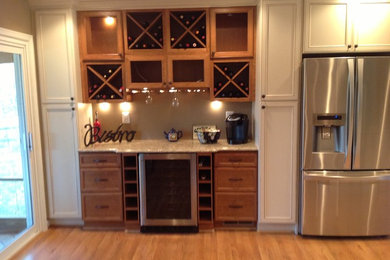 Eat-in kitchen - mid-sized mediterranean galley medium tone wood floor eat-in kitchen idea in DC Metro with an undermount sink, recessed-panel cabinets, beige cabinets, quartz countertops, stainless steel appliances and a peninsula