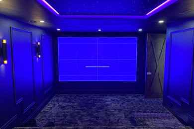 Imagen de cine en casa cerrado minimalista grande con paredes negras, moqueta, pantalla de proyección y suelo negro