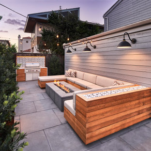 Kleiner, Unbedeckter Moderner Patio hinter dem Haus mit Feuerstelle und Natursteinplatten in San Diego