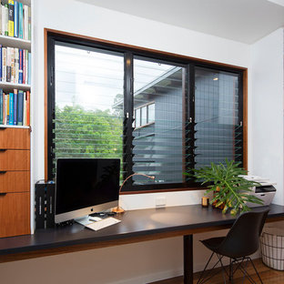 ブリスベンの小さいモダンスタイルのおしゃれなホームオフィス・仕事部屋 (白い壁、無垢フローリング、造り付け机、マルチカラーの床) の写真