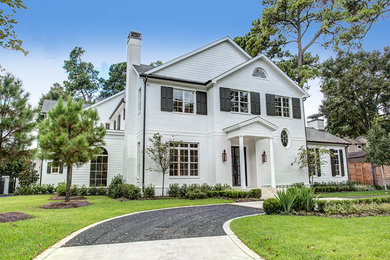 Example of a classic white three-story brick house exterior design in Houston with a mixed material roof