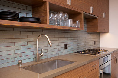 This is an example of a large modern single-wall eat-in kitchen in San Francisco with a single-bowl sink, flat-panel cabinets, dark wood cabinets, quartz benchtops, blue splashback, ceramic splashback, stainless steel appliances, ceramic floors, with island and blue floor.