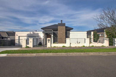 Ejemplo de fachada de casa beige y gris contemporánea grande de dos plantas con revestimiento de hormigón, tejado a cuatro aguas y tejado de teja de barro