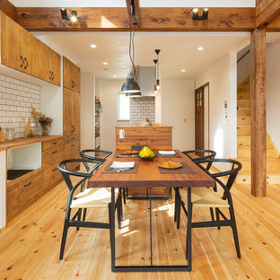 Ispirazione per una sala da pranzo aperta verso il soggiorno etnica con pareti bianche, parquet chiaro e pavimento beige