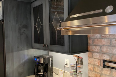 Mid-sized farmhouse medium tone wood floor and exposed beam kitchen photo in Providence with an undermount sink, flat-panel cabinets, blue cabinets, quartz countertops, brick backsplash, black appliances, an island and white countertops