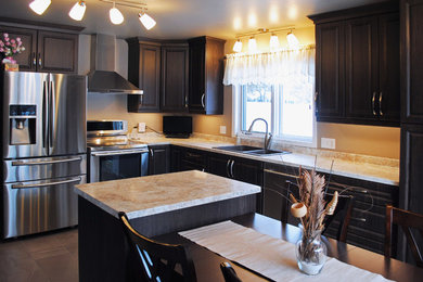 Eat-in kitchen - mid-sized traditional l-shaped ceramic tile eat-in kitchen idea in Toronto with a drop-in sink, raised-panel cabinets, dark wood cabinets, laminate countertops, stainless steel appliances and an island
