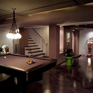 Large modern fully buried basement in New York with grey floors, grey walls and concrete flooring.