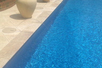 Inspiration for a mid-sized contemporary backyard stone and rectangular natural pool remodel in Other