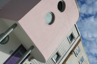 This is an example of a medium sized and multi-coloured contemporary semi-detached house in Sussex with three floors, mixed cladding, a flat roof and a mixed material roof.