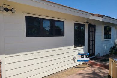 Example of a mid-sized white one-story concrete fiberboard house exterior design in Orange County