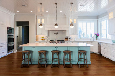 Inspiration for a large contemporary u-shaped open plan kitchen in Salt Lake City with a farmhouse sink, recessed-panel cabinets, white cabinets, quartzite benchtops, white splashback, subway tile splashback, stainless steel appliances, medium hardwood floors, with island and brown floor.