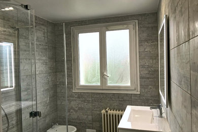 Inspiration pour une salle d'eau traditionnelle de taille moyenne avec un placard à porte affleurante, des portes de placard marrons, une baignoire indépendante, une douche à l'italienne, un bidet, un carrelage gris, des carreaux de céramique, un mur gris, un sol en carrelage de céramique, une vasque, un sol gris, une cabine de douche à porte coulissante et un plan de toilette blanc.