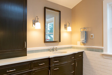 Photo of a mid-sized country master wet room bathroom in Seattle with furniture-like cabinets, distressed cabinets, a claw-foot tub, a two-piece toilet, white tile, ceramic tile, brown walls, porcelain floors, an undermount sink, engineered quartz benchtops, brown floor, a hinged shower door and white benchtops.