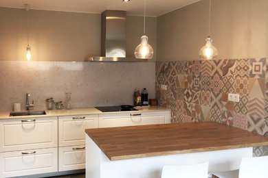 Photo of a small scandinavian galley open plan kitchen in Barcelona with an undermount sink, raised-panel cabinets, white cabinets, wood benchtops, stainless steel appliances, ceramic floors and a peninsula.