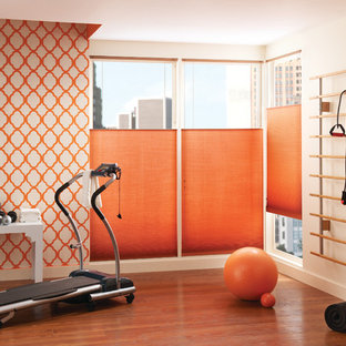 他の地域の大きいコンテンポラリースタイルのおしゃれな多目的ジム (オレンジの壁、無垢フローリング、オレンジの床) の写真