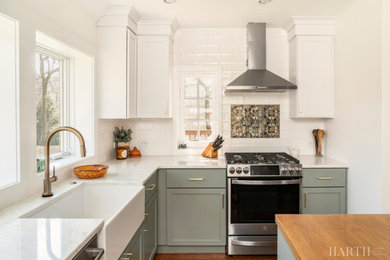 Enclosed kitchen - mid-sized country l-shaped medium tone wood floor and brown floor enclosed kitchen idea in Philadelphia with a farmhouse sink, shaker cabinets, green cabinets, quartz countertops, white backsplash, subway tile backsplash, stainless steel appliances, an island and white countertops
