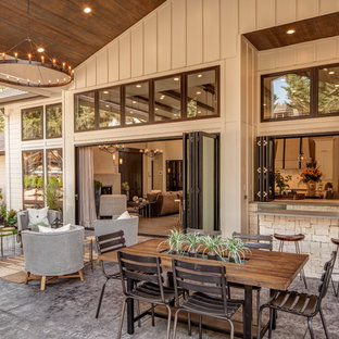 ポートランドの大きいカントリー風おしゃれな裏庭のテラス (アウトドアキッチン、スタンプコンクリート舗装、張り出し屋根) の写真