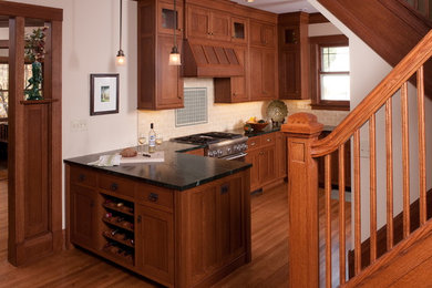 Eat-in kitchen - craftsman u-shaped eat-in kitchen idea in Chicago with an undermount sink, shaker cabinets, medium tone wood cabinets, soapstone countertops, beige backsplash, subway tile backsplash and stainless steel appliances