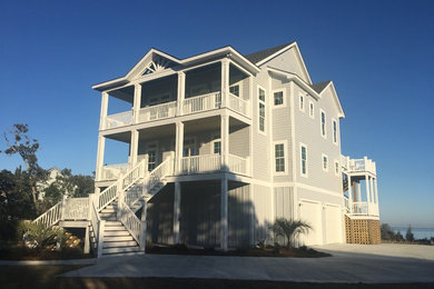 Large coastal gray three-story wood gable roof idea in Other