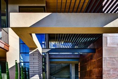 Inspiration for a mid-sized contemporary concrete porch remodel in Phoenix with a roof extension