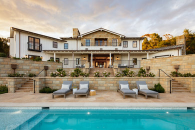Inspiration for a huge cottage white two-story house exterior remodel in Santa Barbara with a hip roof and a metal roof