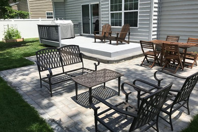 Example of a mid-sized backyard brick patio design in DC Metro with no cover