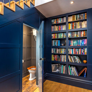 Ejemplo de distribuidor ecléctico, grande, con paredes azules, suelo de madera oscura, puerta simple y puerta gris
