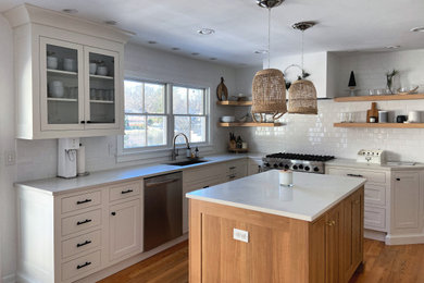 Open concept kitchen - large contemporary u-shaped medium tone wood floor and brown floor open concept kitchen idea in New York with an undermount sink, shaker cabinets, white cabinets, quartz countertops, white backsplash, subway tile backsplash, stainless steel appliances, an island and white countertops