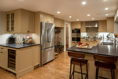 Eat-in kitchen - transitional light wood floor eat-in kitchen idea in Boston with an undermount sink, shaker cabinets, multicolored backsplash, subway tile backsplash, stainless steel appliances, a peninsula, beige cabinets and granite countertops